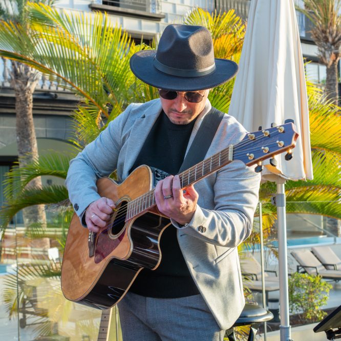 Guitarrista Yusniel Capote actuando con guitarra acústica.